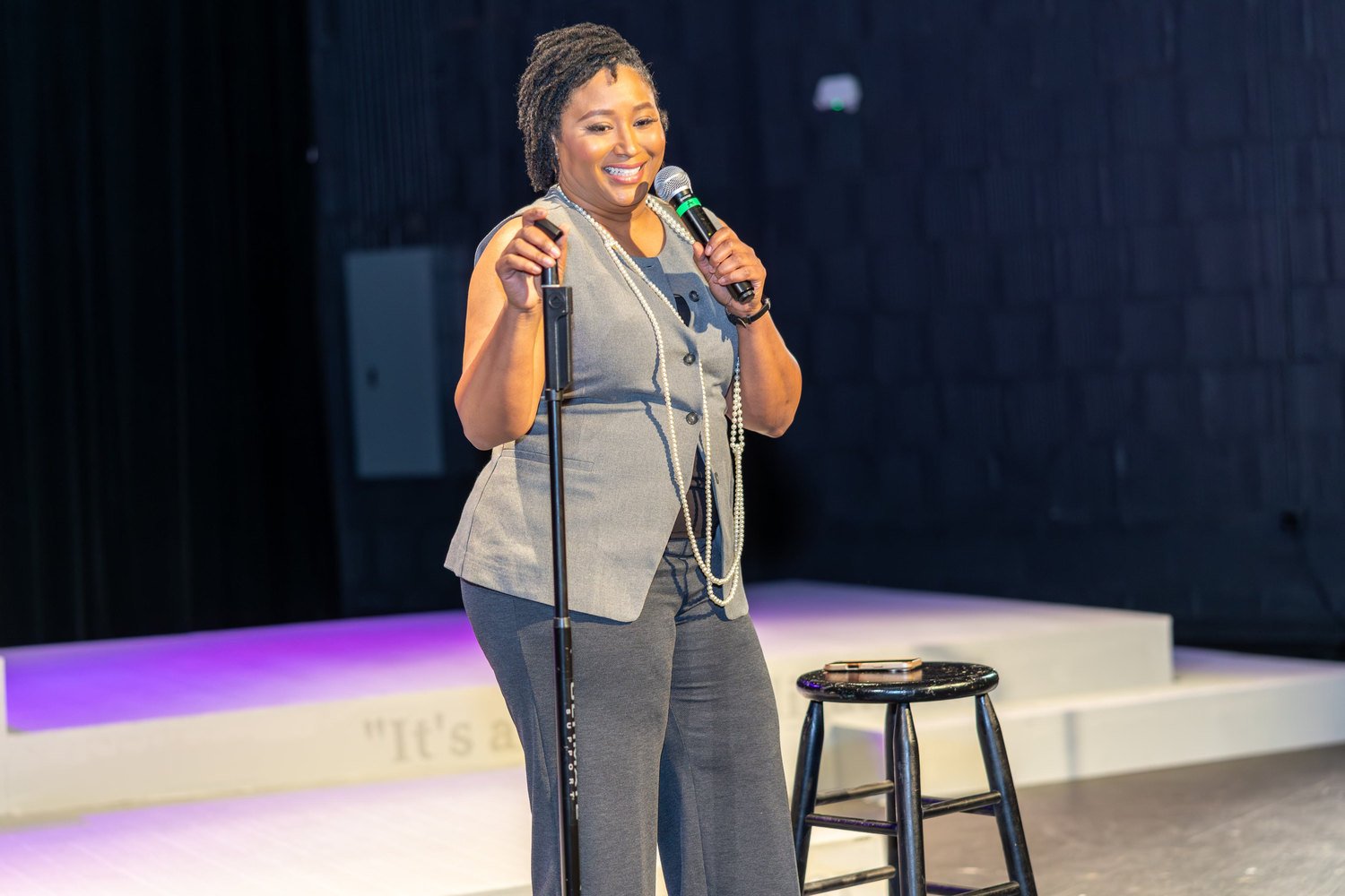 A woman speaking into a microphone on stage