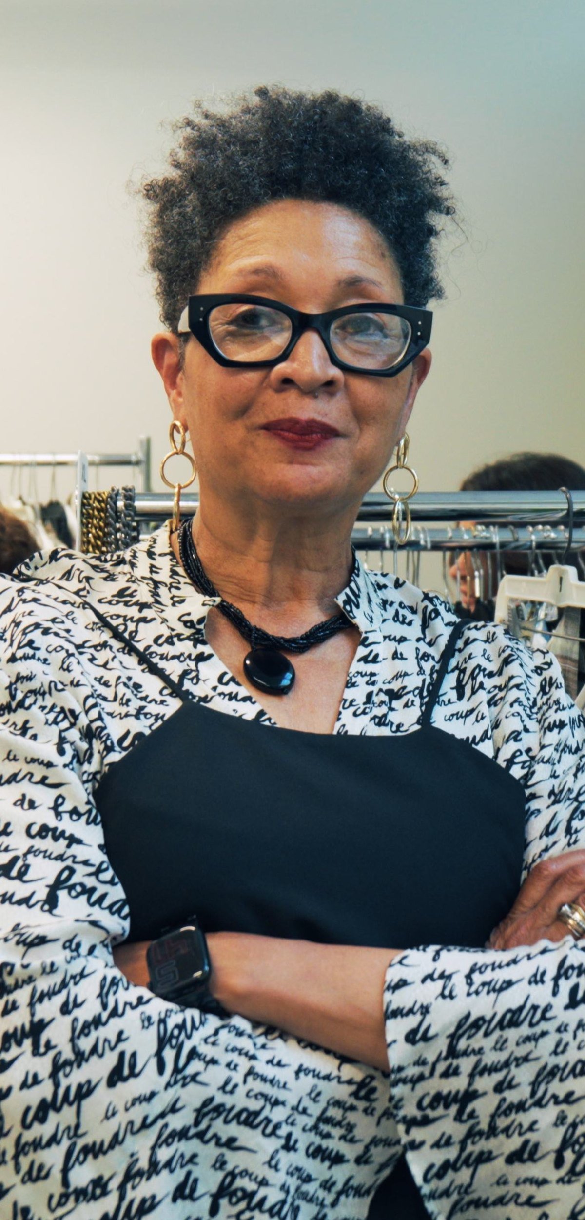 A business owner standing with her arms folded in her shop